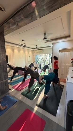 Students transitioning through Eka Pada Adho Mukha Svanasana