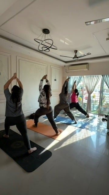 Students in Warrior Pose variation during class